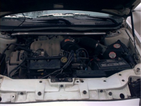 1997 Ford Taurus - The engine bay of a 1997 Ford Taurus is shown, with the 3.0 V6 engine clearly visible.