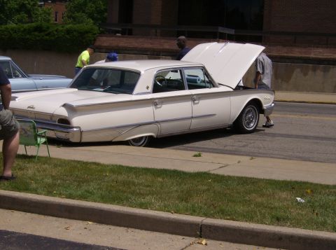 1970 Ford Ranchero - A white 1960 sedan is parked with its hood open, alongside another vehicle.