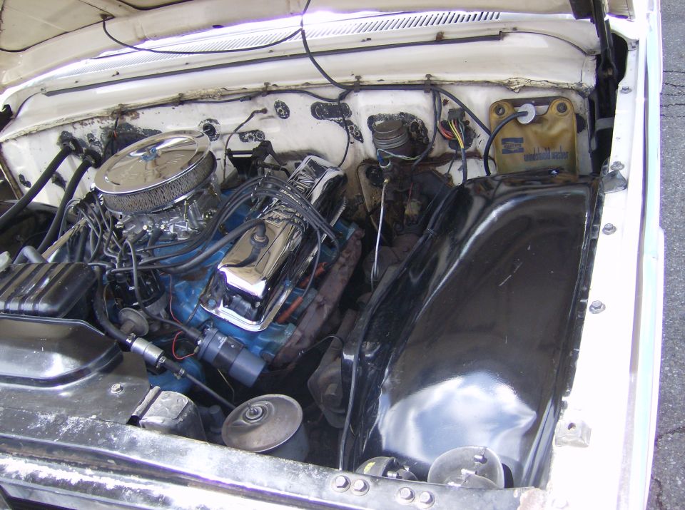 Engine bay with V8 engine, chrome air cleaner, and blue valve covers
