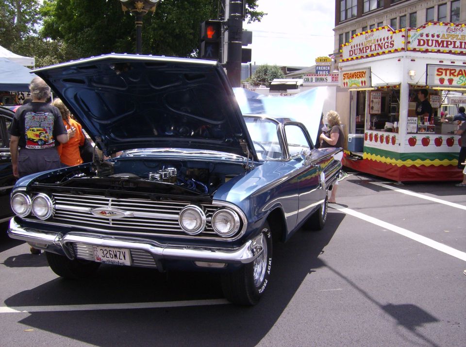 Blue 1960 Chevrolet Impala with hood open at a car show
