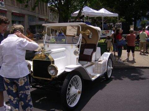 1970 Ford Ranchero - An antique white car is on display at an outdoor event with people around.