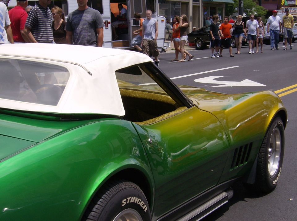 Green and yellow convertible with white top, side view. Stinger tires