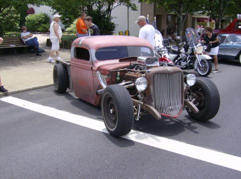 1970 Ford Ranchero - A custom hot rod pickup truck with a prominent V8 engine is displayed at an outdoor event.
