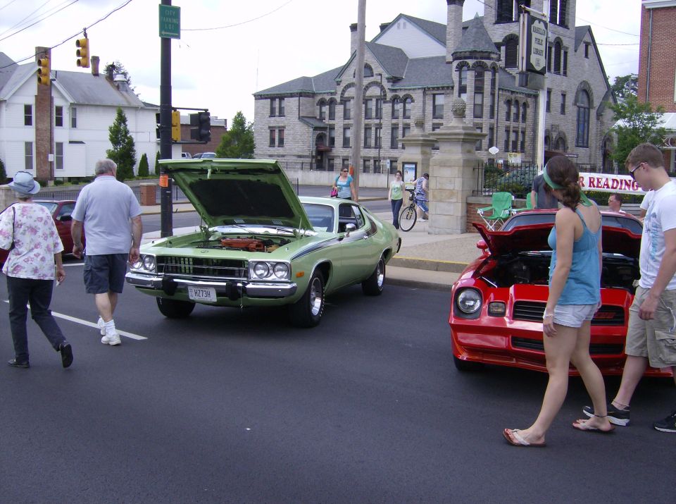 Light green 1974 coupe with hood open, parked on street
