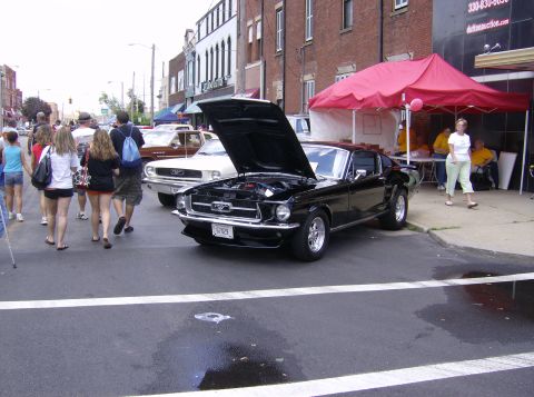 1970 Ford Ranchero - Black 1967 Ford Mustang on display at an outdoor car show event.