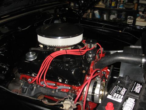 1966 Ford F-100 - Engine bay detail with a V8 engine, red spark plug wires, and a chrome air filter. A battery is also visible.