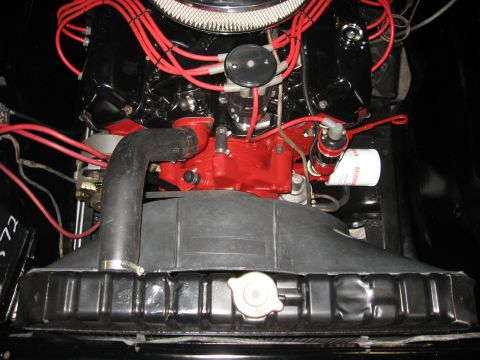 1966 Ford F-100 - Close-up view of a vehicle's engine bay, red spark plug wires and a black engine block.