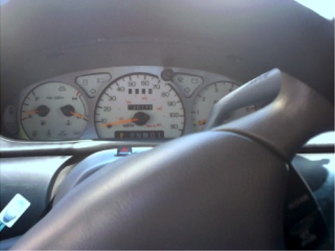 1997 Ford Taurus - The car's dashboard shows the odometer reading and various gauges, with the steering wheel in the foreground.