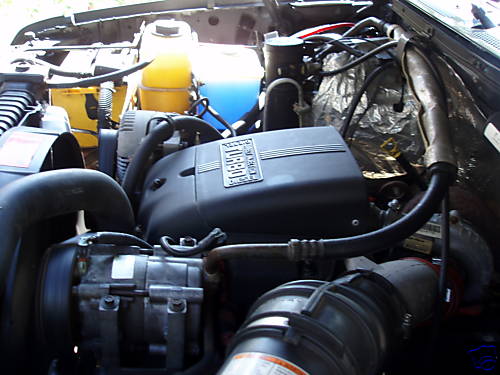 Engine bay with "TURBO" inscribed on a black cover