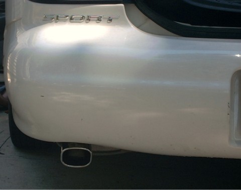 1997 Ford Taurus - The rear bumper of a white car features a "SPORT" badge and an oval exhaust tip.