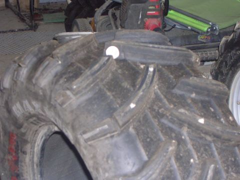 2008 Bombardier Outlander - A close-up view of a large, off-road tire with aggressive tread patterns is shown.