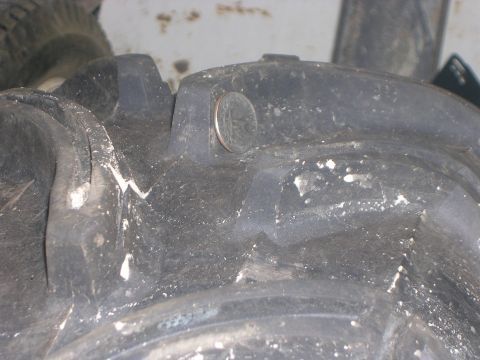 2008 Bombardier Outlander - A quarter is placed on the tread of a heavily used ATV tire, showing its aggressive pattern.