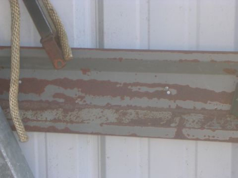 2008 Bombardier Outlander - A close-up of a weathered metal surface shows signs of rust and peeling paint.
