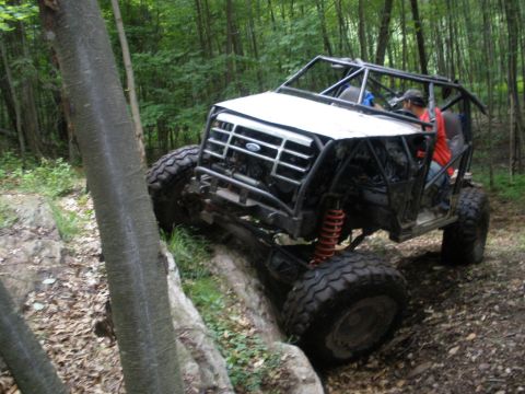 1995 Ford Bronco - This heavily modified buggy navigates a rocky trail through a wooded area.