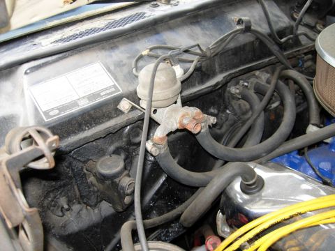 1970 Ford Ranchero - Close-up view of engine bay components, including hoses and a valve, with a visible service sticker on the firewall.