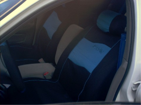 1997 Ford Taurus - The interior of a car shows custom seat covers with blue and black fabric, obscuring the original upholstery.