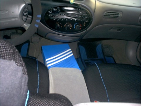 1997 Ford Taurus - The interior of a car is shown, a dashboard with radio and climate controls, and seats with blue accents.