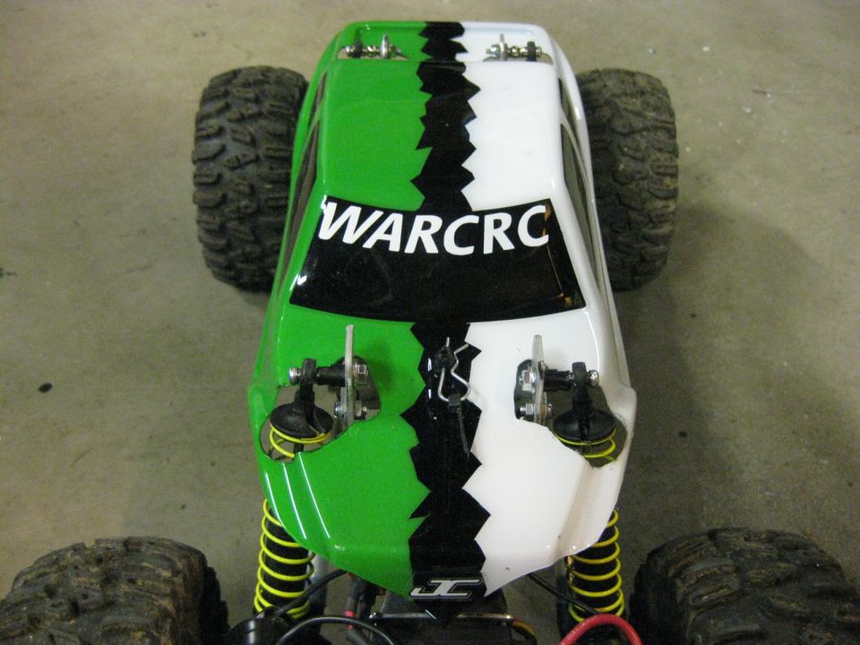 Remote control car body, green and white with black jagged stripe, 'WARCRC' text, visible suspension and tires