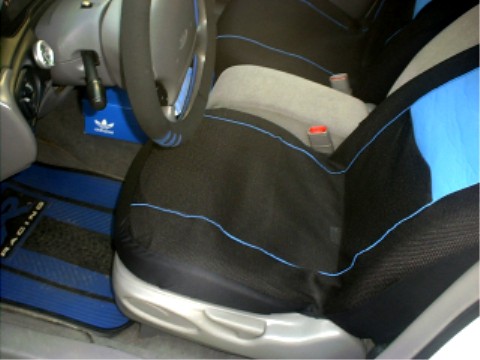 1997 Ford Taurus - The interior of a 1997 Ford Taurus features custom black and blue seat covers and blue racing floor mats.