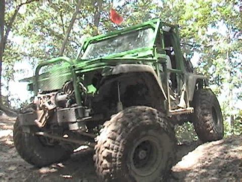 1992 Ford Bronco - This heavily modified off-road vehicle navigates a challenging dirt path.