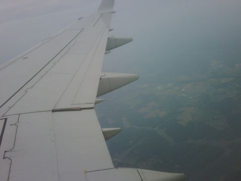 1996 Ford Bronco - View from an airplane window shows the wing and the hazy landscape below.