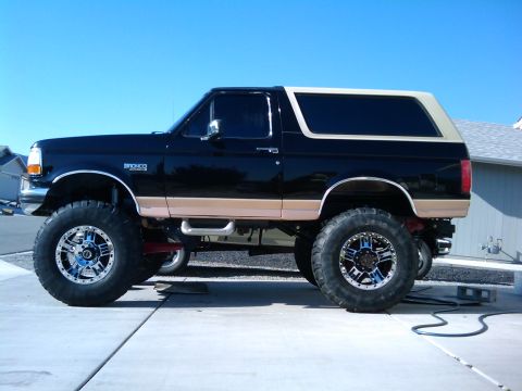 1994 Ford Bronco - Side profile of a modified 1994 Ford Bronco with large tires and aftermarket wheels.
