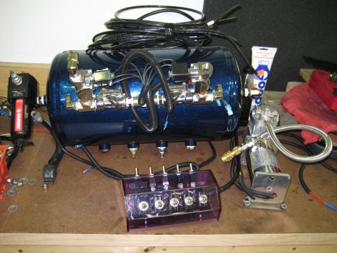 1996 Chevrolet Cavalier - This setup includes an air compressor, a blue glitter tank, and a control box with multiple switches.
