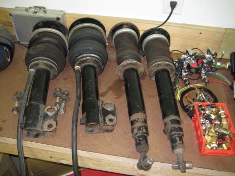 1996 Chevrolet Cavalier - Air suspension struts and various fittings are laid out on a workbench.