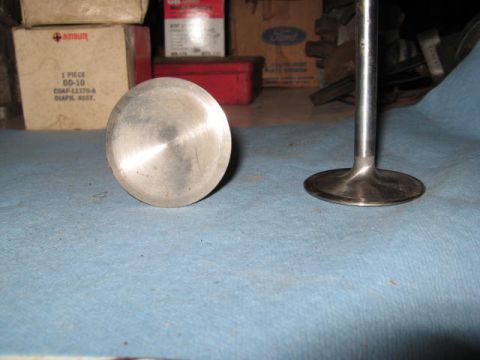 1963 Ford Galaxie - A close-up view of an engine valve, with another valve stem visible to the right, set against a backdrop of storage boxes.