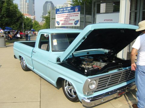 2007 Ford Mustang - A light blue 1967 Ford F-100 pickup truck is displayed with its hood open, revealing the engine bay.