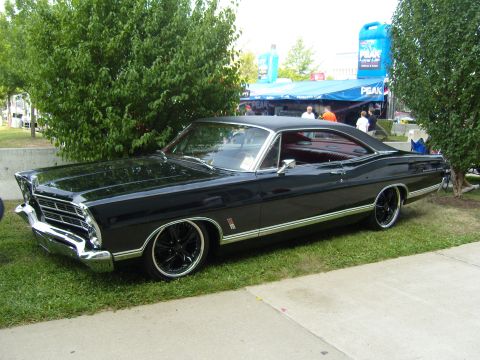 2007 Ford Mustang - A black 1967 Ford Galaxie 500 coupe is parked on grass with custom wheels and chrome trim.