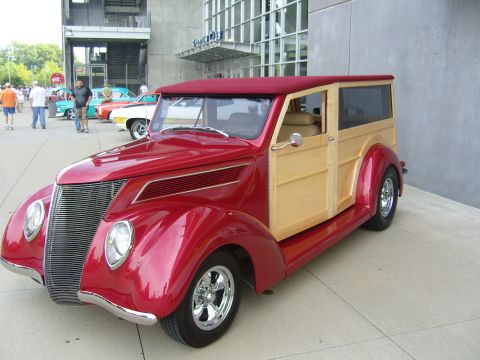 2007 Ford Mustang - Classic 1937 Ford station wagon with a two-tone red and wood body, seen at an outdoor event.