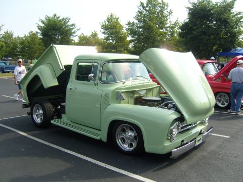 2007 Ford Mustang - A light green 1956 Ford F-100 pickup truck is displayed with its hood and bed open at a car show.
