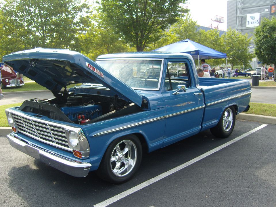 Blue 1967 Ford F-100 pickup truck, hood open, showing engine