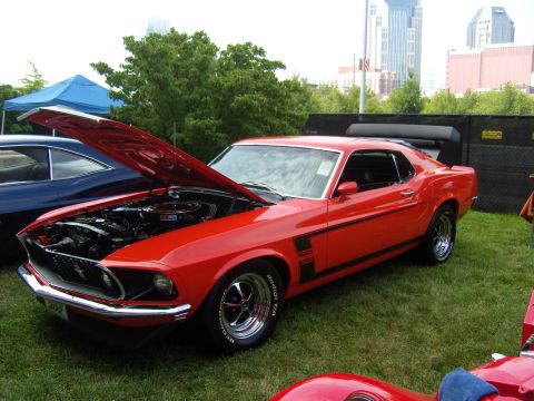 2007 Ford Mustang - 1969 Ford Mustang Boss 302 on display with its hood open, parked next to another vehicle.