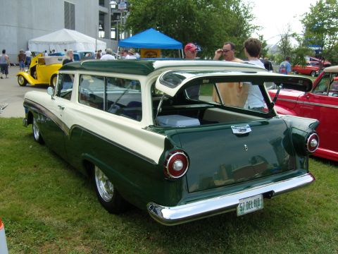2007 Ford Mustang - A two-tone green and white 1957 Ford station wagon is parked on grass with its rear hatch open, showing a cooler inside.