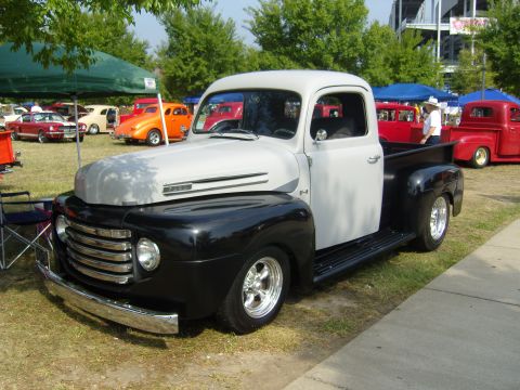 2007 Ford Mustang - A classic pickup truck is displayed at an outdoor car show with other vehicles visible.