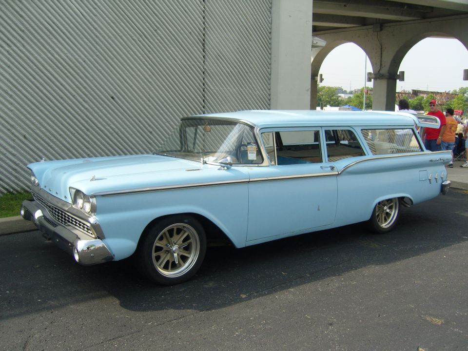 Light blue 1959 Ford station wagon with chrome trim and aftermarket wheels, viewed from the side