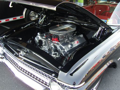 2007 Ford Mustang - A highly polished V8 engine is visible under the hood of a black car, with another car in the background.
