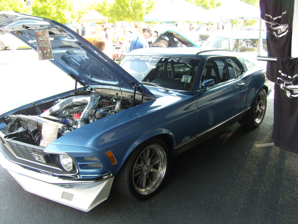 Blue 1970 Ford Mustang with hood open showing engine, aftermarket front splitter
