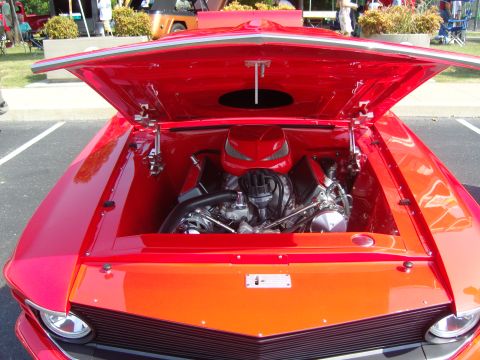 2007 Ford Mustang - The engine bay of a classic red car, possibly a 1967 Ford Mustang, is displayed with the hood open.