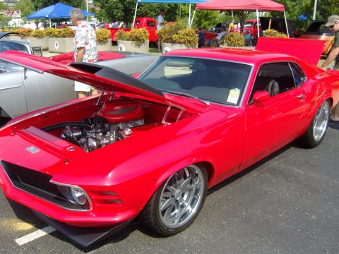 2007 Ford Mustang - A bright red 1970 Ford Mustang is displayed with its hood open, revealing the engine and custom wheels.