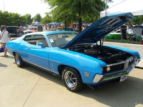2007 Ford Mustang - A bright blue classic car is displayed with its hood open, revealing the engine compartment.