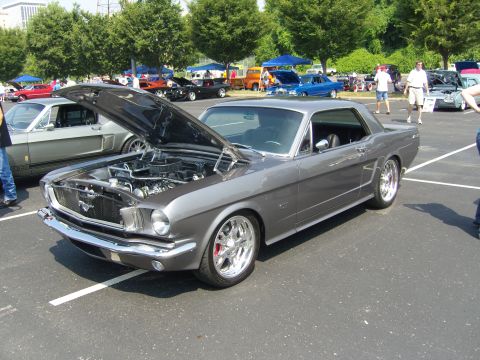 2007 Ford Mustang - A classic gray Ford Mustang is displayed at an outdoor car show with its hood open.