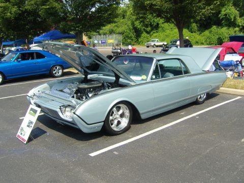 2007 Ford Mustang - A light blue 1961 Ford Thunderbird is displayed with its hood and trunk open at an outdoor car show.
