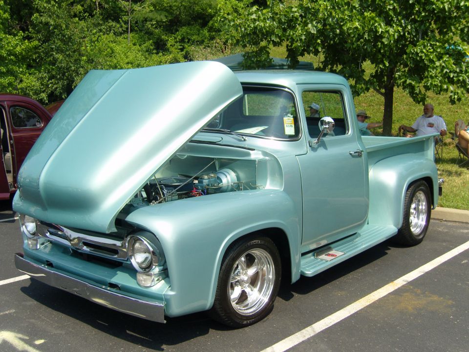 Light blue 1956 Ford F-100 pickup truck with hood open, chrome wheels, and custom paint