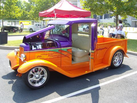 2007 Ford Mustang - Custom hot rod pickup truck with vibrant orange and purple paint, flame graphics, and exposed engine compartment.