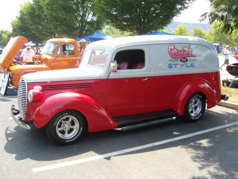 2007 Ford Mustang - A two-tone red and white panel van, identified as "Crush 39 Style", is parked at an outdoor event.