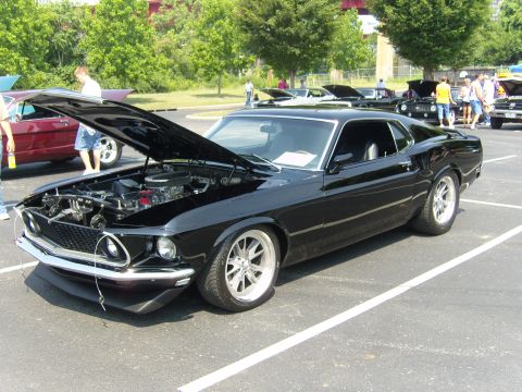 2007 Ford Mustang - Classic black Ford Mustang on display at a car show, hood up to reveal the engine.