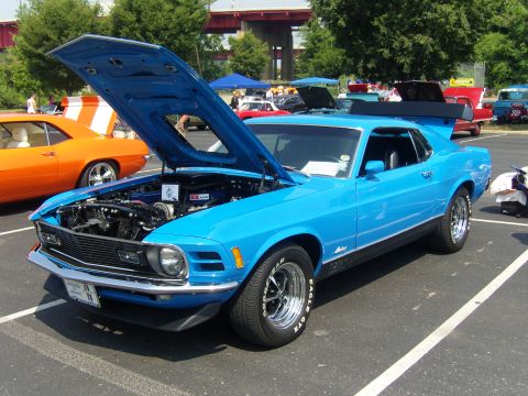 2007 Ford Mustang - A bright blue classic Mustang is displayed with its hood up at an outdoor car show.